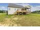 View of the home's rear exterior featuring a spacious wooden deck and a screened-in porch at 243 Kissington Way, Benson, NC 27504