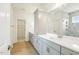 Modern bathroom featuring dual sinks, quartz countertop, and a tiled shower with glass door at 243 Kissington Way, Benson, NC 27504