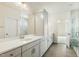 Spacious bathroom with dual sink vanity, wood-look floors, and a tiled glass door shower at 243 Kissington Way, Benson, NC 27504