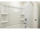 White shower and tub combination with built-in shelving and chrome fixtures at 243 Kissington Way, Benson, NC 27504