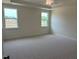 The bedroom has two windows and neutral carpet at 243 Kissington Way, Benson, NC 27504