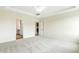 Bright bedroom with plush carpet, ceiling fan, and access to a bathroom and kitchen area at 243 Kissington Way, Benson, NC 27504