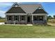Charming home featuring stone accents, a covered porch, and beautifully landscaped front yard at 243 Kissington Way, Benson, NC 27504