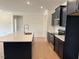 Kitchen with stainless steel appliances, island with quartz countertop, and dark cabinets at 243 Kissington Way, Benson, NC 27504