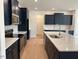 Kitchen featuring white countertops, dark cabinets, stainless steel appliances, and backsplash at 243 Kissington Way, Benson, NC 27504