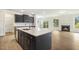 Open concept kitchen with island, stainless steel appliances, and fireplace in the living room at 243 Kissington Way, Benson, NC 27504