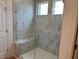 The shower has grey tiling and windows for light at 243 Kissington Way, Benson, NC 27504