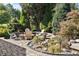 Landscaped backyard with stone patio, outdoor seating and tranquil water feature, perfect for relaxation at 2526 Snowdrop Ct, Apex, NC 27502