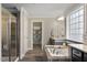 A bathroom featuring tiled floors and tub, granite countertops and dark wood cabinets at 2526 Snowdrop Ct, Apex, NC 27502