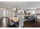 Open-concept dining area with seating for six, leading to a modern kitchen with white cabinets and granite countertops at 2526 Snowdrop Ct, Apex, NC 27502