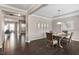 Open-concept dining room features hardwood floors, modern light fixture, and an adjacent room at 2526 Snowdrop Ct, Apex, NC 27502