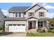 Charming two-story home with a two-car garage, stone accents, and a welcoming front porch at 2526 Snowdrop Ct, Apex, NC 27502