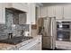 Modern kitchen with stainless steel appliances, granite countertops, and tile backsplash at 2526 Snowdrop Ct, Apex, NC 27502
