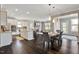 Open concept kitchen, dining and living area with hardwood floors and stone fireplace at 2526 Snowdrop Ct, Apex, NC 27502
