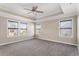 This main bedroom offers three bright windows and neutral walls and carpet at 2526 Snowdrop Ct, Apex, NC 27502