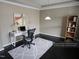 Comfortable home office with hardwood floors, tray ceiling, a modern desk, and a bookcase at 2526 Snowdrop Ct, Apex, NC 27502