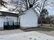 Exterior shot of the backyard with a dark porch, concrete patio, view of the street and sliding glass doors at 334 E Andrews Ave, Henderson, NC 27536