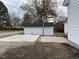 View of the backyard with a concrete patio and a white shed that adds character to the property at 334 E Andrews Ave, Henderson, NC 27536