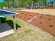 Backyard featuring fresh pine straw, new plantings, and a covered patio at 367 Duncan Creek Rd # 129, Lillington, NC 27546