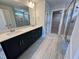 Bathroom featuring dual sink vanity, tiled floors, a glass-enclosed shower, and linen closet at 367 Duncan Creek Rd # 129, Lillington, NC 27546