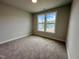 Bright bedroom features neutral walls, carpet, and a double window with neighborhood views at 367 Duncan Creek Rd # 129, Lillington, NC 27546