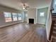 Spacious living room with fireplace, ceiling fan, wood floors, and several windows at 367 Duncan Creek Rd # 129, Lillington, NC 27546