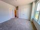 Cozy carpeted bedroom with neutral walls, spacious closets, and a bright window at 403 Duncan Creek Rd # 131, Lillington, NC 27546