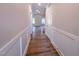 Hallway with wood-look floors and wainscoting, leading to various rooms in the home and a staircase at 403 Duncan Creek Rd # 131, Lillington, NC 27546