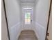 Hallway with wainscoting and wood-look flooring leads to the white front door with transom window at 403 Duncan Creek Rd # 131, Lillington, NC 27546