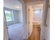 View from hallway to bedroom with carpet and a window, as well as the bathroom with white tub and floors at 403 Duncan Creek Rd # 131, Lillington, NC 27546