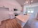 Bright kitchen features white cabinets, stainless appliances, an island, and hardwood flooring at 403 Duncan Creek Rd # 131, Lillington, NC 27546