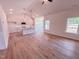 Open-concept living room with wood floors, recessed lighting, and a view of the modern kitchen at 403 Duncan Creek Rd # 131, Lillington, NC 27546