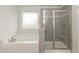 Bathroom showcasing a soaking tub and tiled shower with glass doors at 590 Glenkirk Pl, Garner, NC 27529
