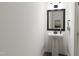 Modern powder room featuring a pedestal sink, framed mirror, and neutral color palette at 702 Portia Way, Homesite 16, Morrisville, NC 27560