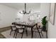Bright dining area with a modern chandelier, a wooden table, and an open view to the kitchen at 702 Portia Way, Homesite 16, Morrisville, NC 27560