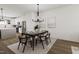Bright dining room featuring a modern chandelier, dining table, and an open view to the kitchen at 702 Portia Way, Homesite 16, Morrisville, NC 27560