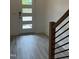 Light and bright entryway with modern gray floors and a three-paneled door with a black handle at 702 Portia Way, Homesite 16, Morrisville, NC 27560