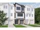 New construction townhome featuring a brick facade, a gray garage door, and manicured landscaping at 702 Portia Way, Homesite 16, Morrisville, NC 27560