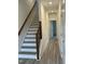 Hallway with gray floors, stairs with an ornamental railing, and white walls with white doors at 702 Portia Way, Homesite 16, Morrisville, NC 27560