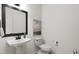 Stylish powder room featuring a modern sink, black hardware, toilet, and elegant artwork at 704 Portia Way, Homesite 15, Morrisville, NC 27560