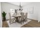 Charming dining room features a wooden table, six chairs, modern chandelier, and access to the backyard at 704 Portia Way, Homesite 15, Morrisville, NC 27560