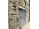 Close-up on a stylish, wood-look garage door with brick accents and house numbers at 704 Portia Way, Homesite 15, Morrisville, NC 27560