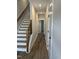 Inviting hallway featuring hardwood floors, white trim, and modern staircase design at 704 Portia Way, Homesite 15, Morrisville, NC 27560