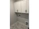 Efficient laundry room with overhead cabinets and marble-look tile flooring at 704 Portia Way, Homesite 15, Morrisville, NC 27560