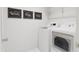 Well-lit laundry room equipped with modern washer and dryer units, and decorative wall art at 704 Portia Way, Homesite 15, Morrisville, NC 27560