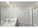 A bright bathroom with a double sink vanity, large mirror, and stand-up shower with clear glass doors at 1128 Middlecrest Dr, Rocky Mount, NC 27804