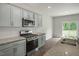 A kitchen with light gray cabinets, stainless steel appliances, and granite countertops at 1128 Middlecrest Dr, Rocky Mount, NC 27804