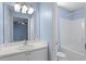 Bright bathroom with vanity, tiled floor, and combined tub and shower with a blue accent wall at 2248 Ventana Ln, Raleigh, NC 27604