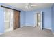 Spacious bedroom with sliding barn door leading to ensuite bathroom, and a modern ceiling fan at 2248 Ventana Ln, Raleigh, NC 27604