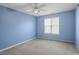 Clean and bright bedroom with blue walls, neutral carpet, and a ceiling fan for added comfort at 2248 Ventana Ln, Raleigh, NC 27604